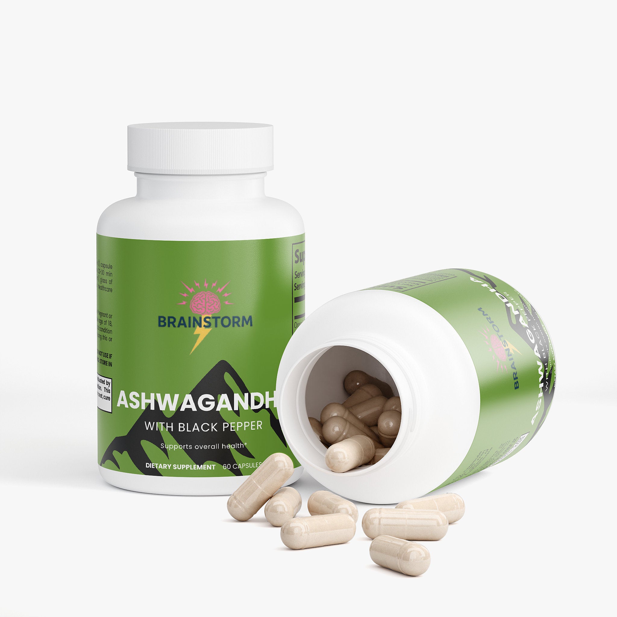 2 Supplement bottles labeled 'Brainstorm Ashwagandha with Black Pepper' one tipped over spilling out ashwagandha capsules on a white background