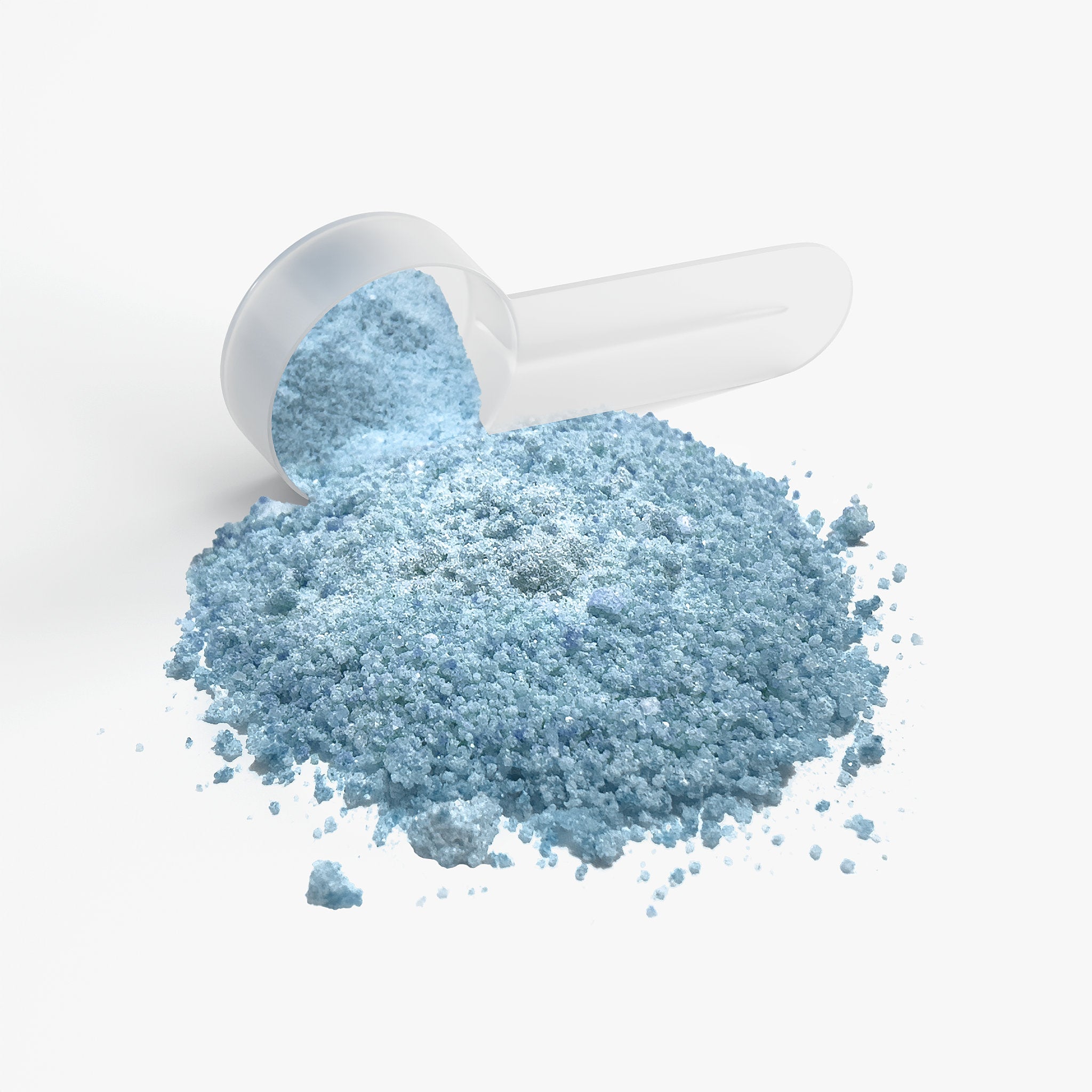 Blue focus powder spilling out of a white scoop on a light gray background